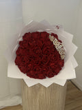 Bouquet Signature Princesse SEVIA – roses rouges, couronne et paillettes, emballage blanc